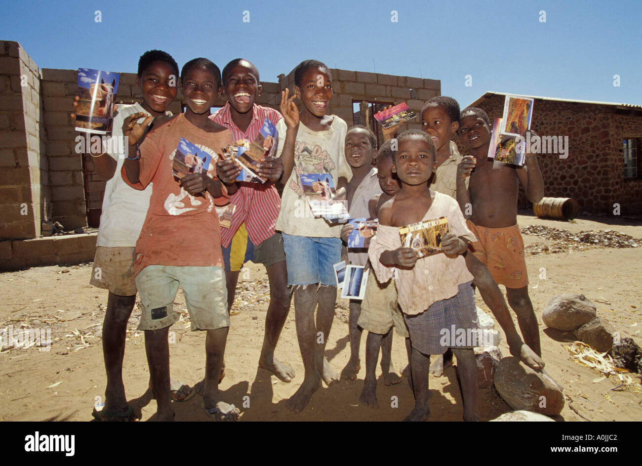 Zimbabwe, Africa  Victoria Falls School Kids Holding up Photographer s Post Cards Stock Photo