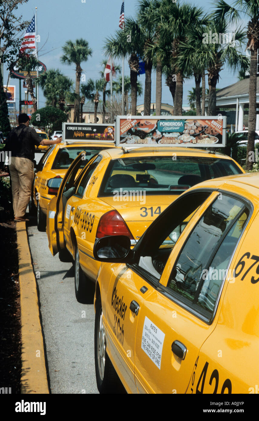 Row of yellow taxis waiting on International Drive Orlando Stock Photo