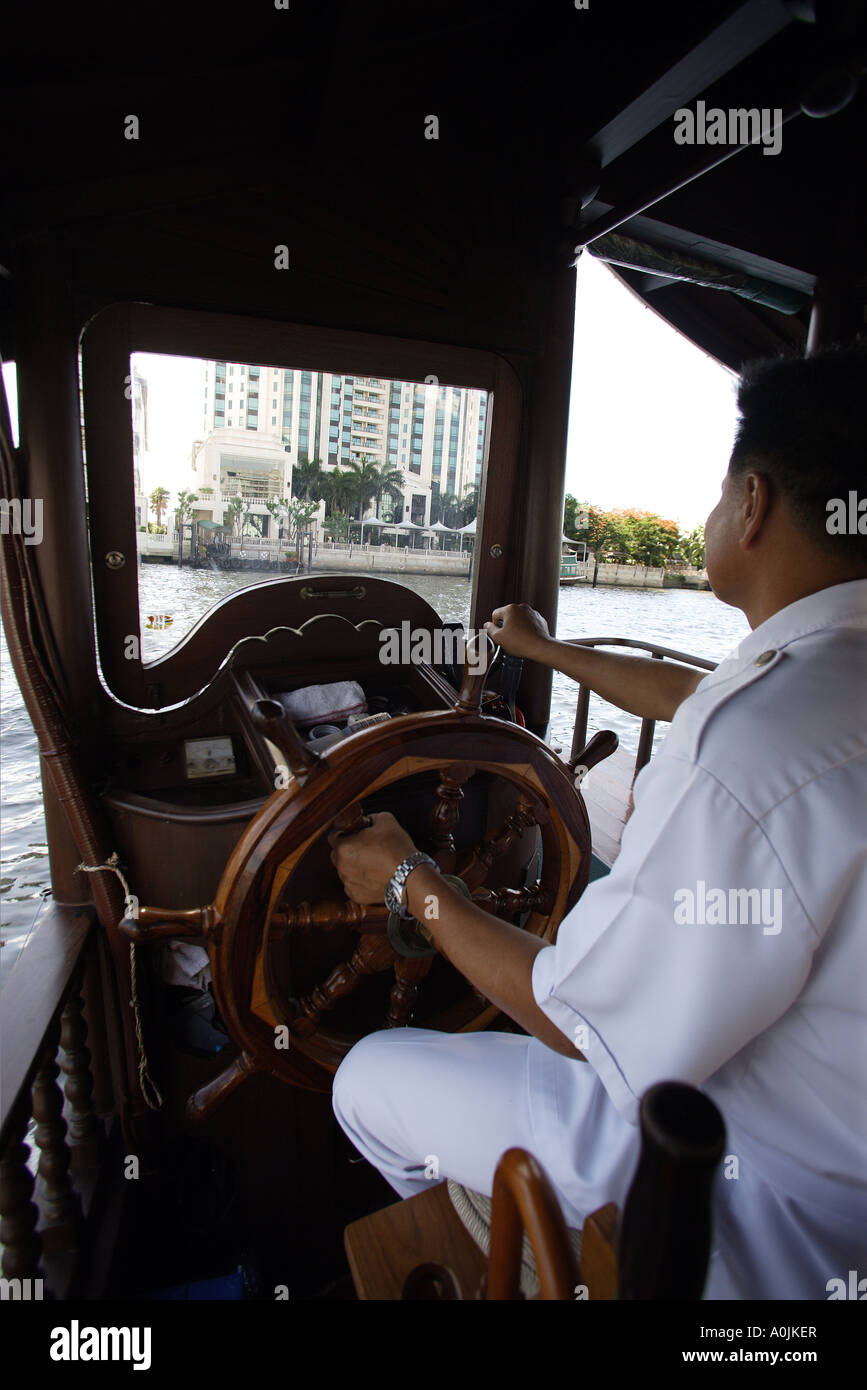 The captain steers the free boat across the Chao Phraya River to the