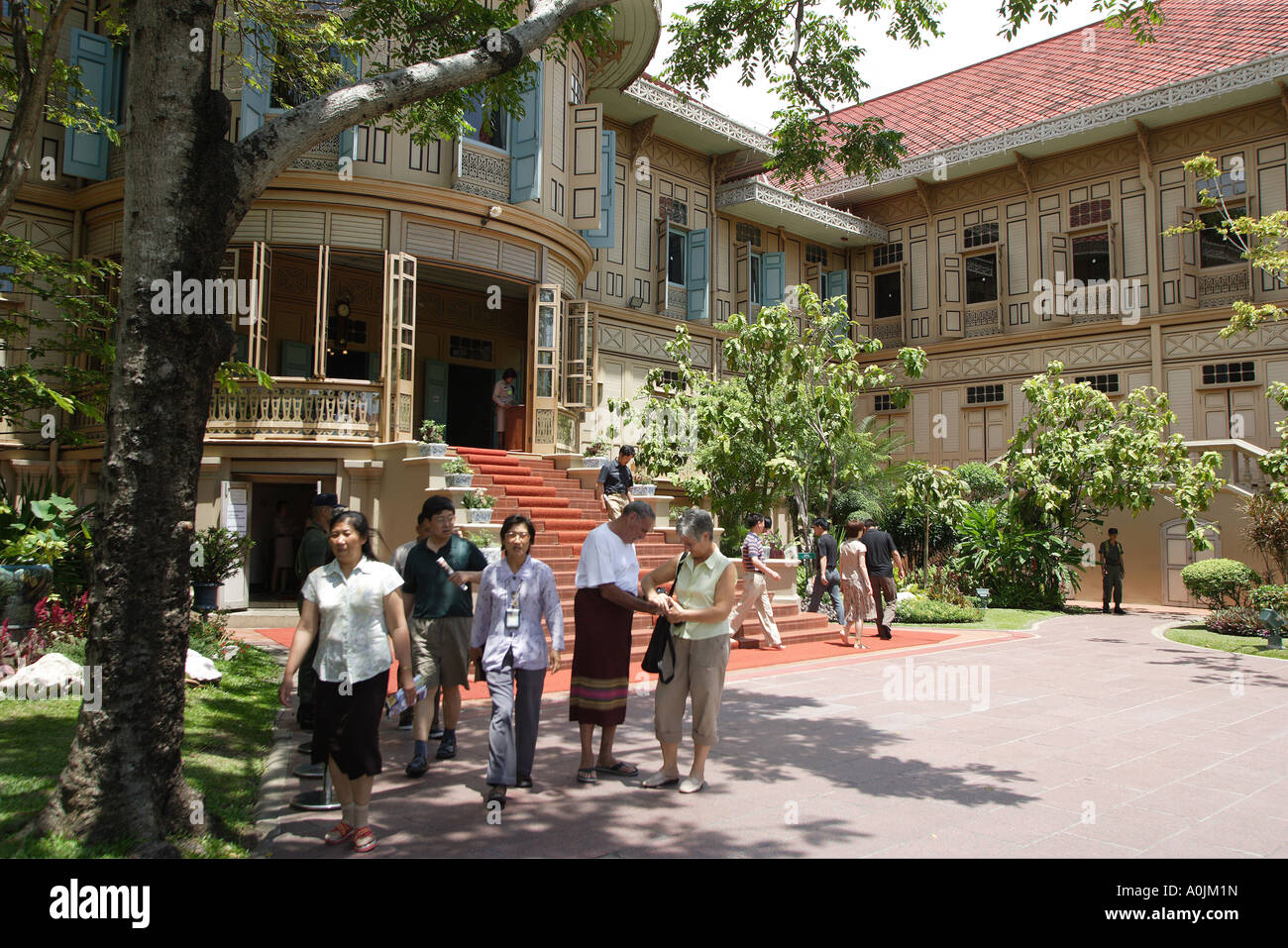 Visitors at Vimanmek Palace in Bangkok Thailand This royal mansion is the largest golden teak building in the world Built by Rama V Chulalongkorn in 1868 as a summer retreat on Ko Si Chang it was moved piece by piece to the current site in 1910 Stock Photo