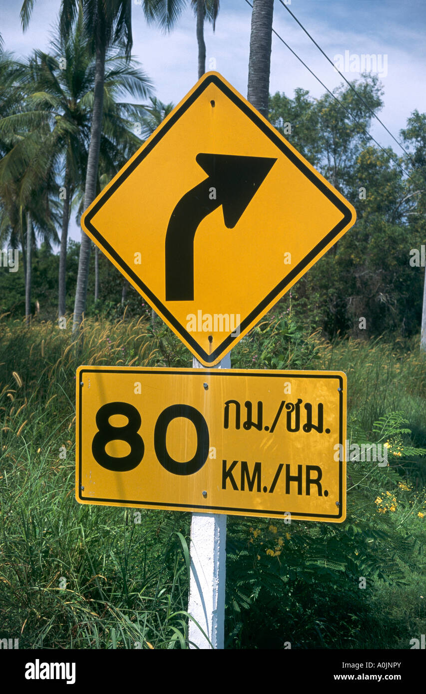 A yellow road sign warning of a sharp curve with a speed limit of Stock