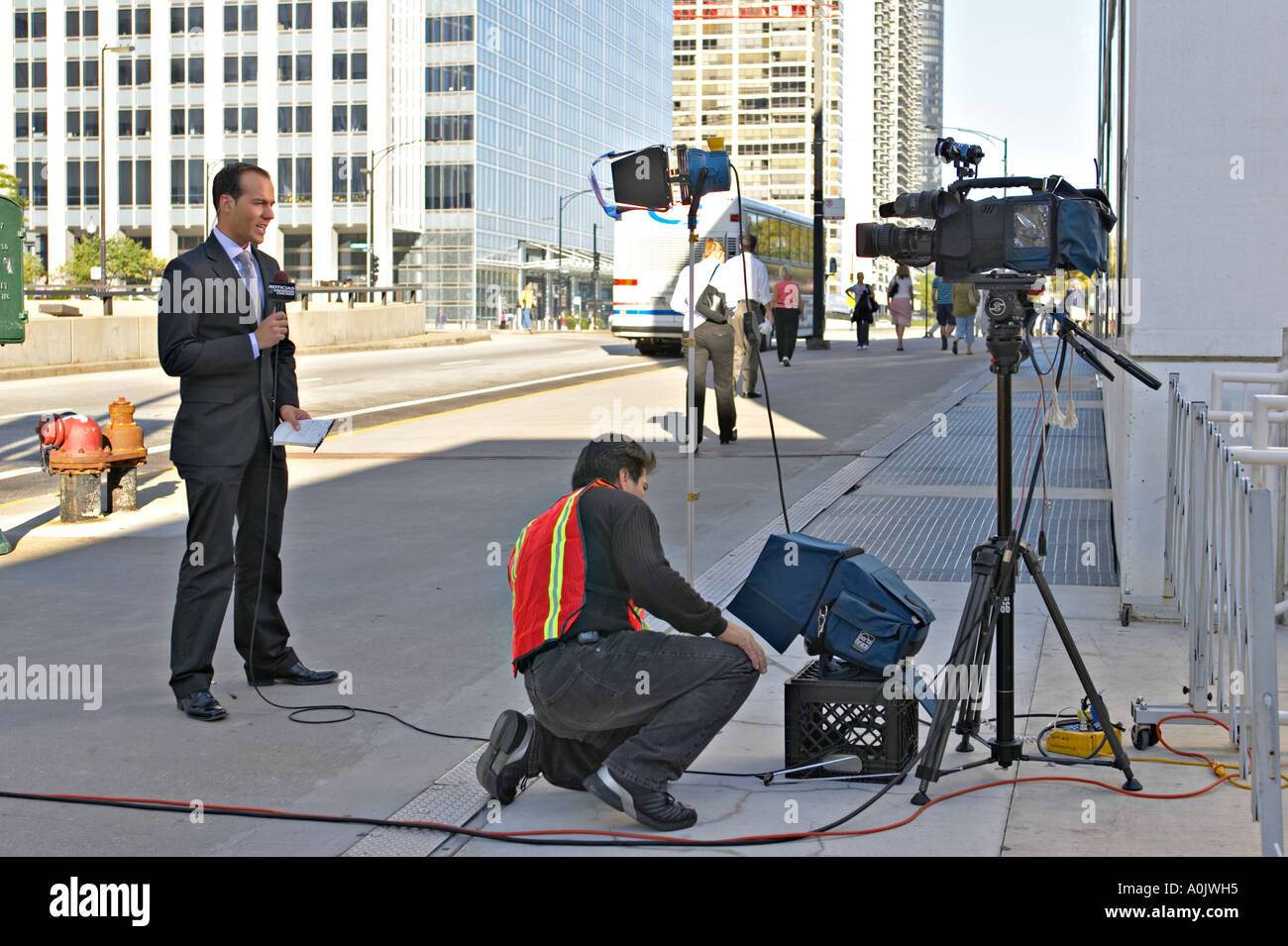 STREET SCENE Chicago Illinois Spanish language male news reporter with cameraman on Randolph Street evening news Stock Photo