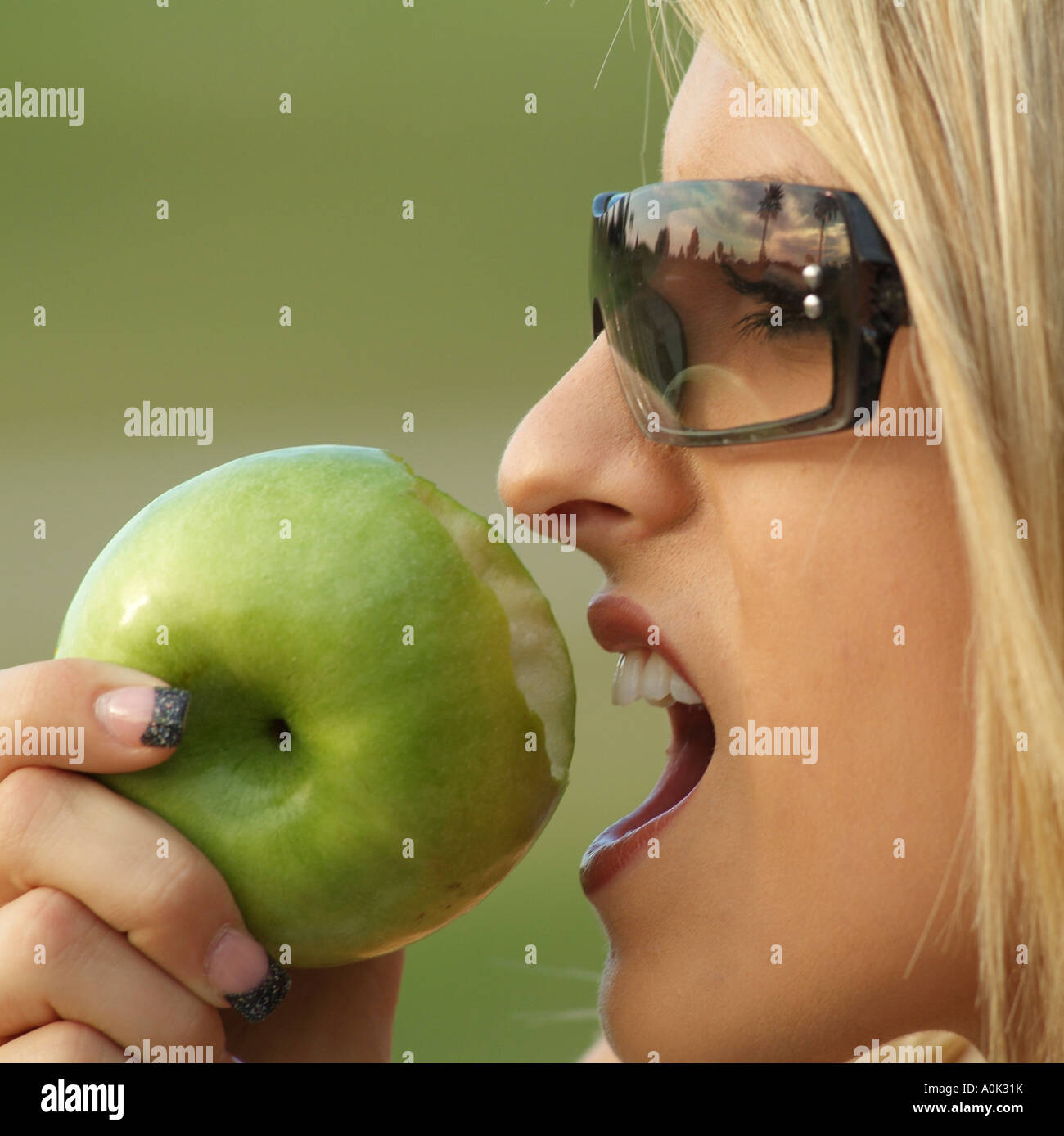 Healthy eating Young woman biting a green apple Stock Photo