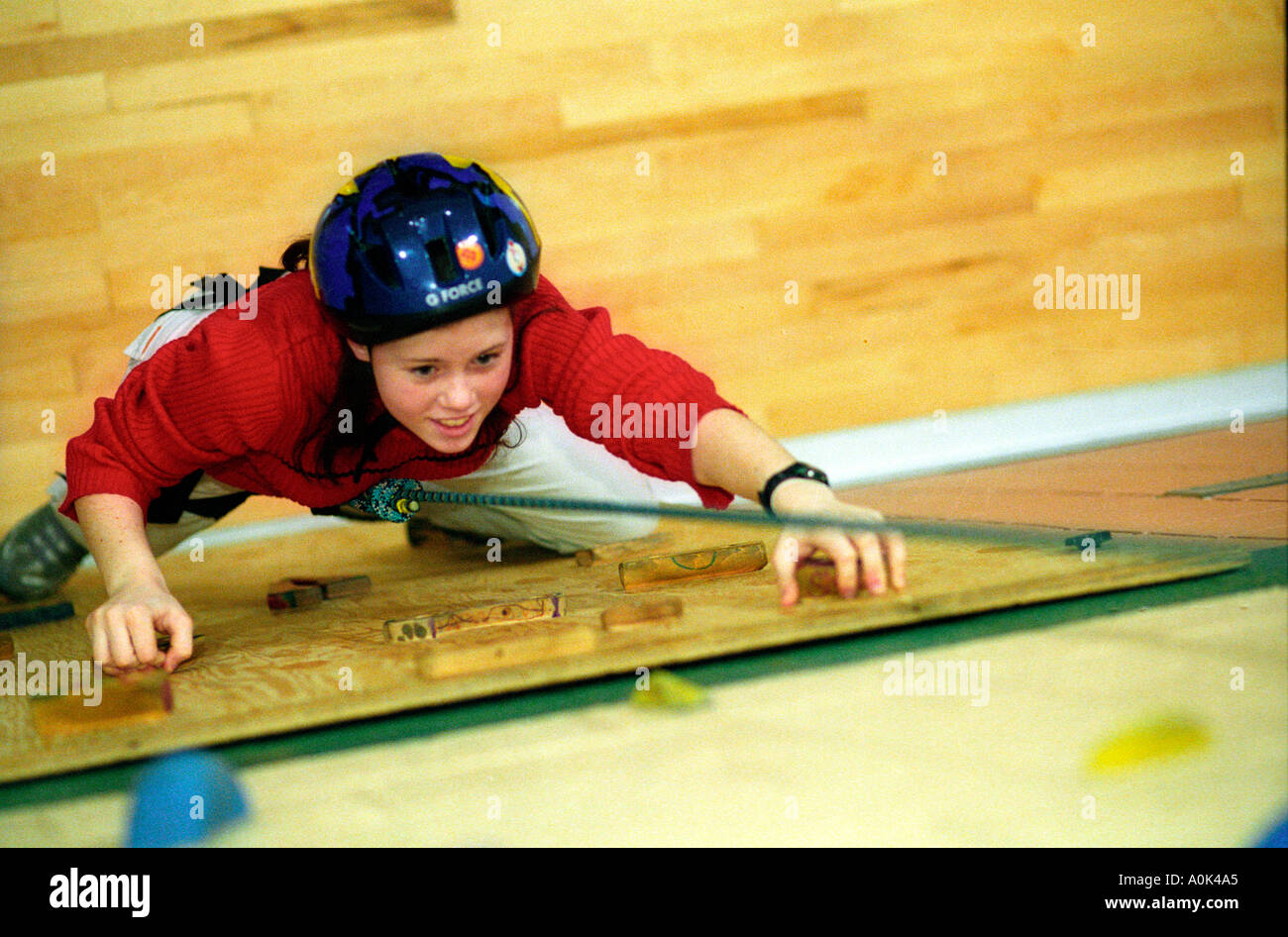 A student on the climbing wall in the gym at Hart Middle School in an