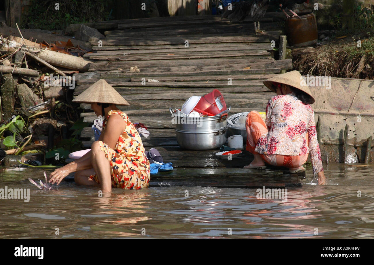 Women washing laundry and dishes in the Mekong Delta, Vietnam Stock Photo