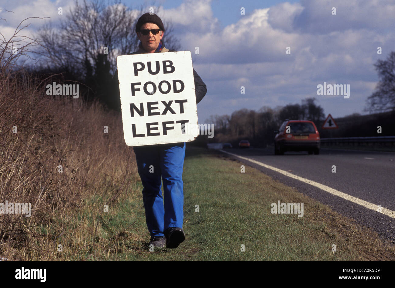 Sandwichboard man advertising a village pub Wiltshire England.HOMER SYKES Stock Photo