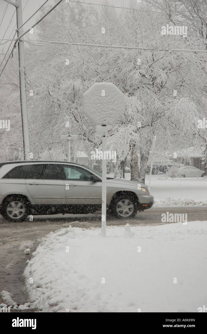 Dodge Magnum drives behind Snow-Covered Stop Sign, Marysville, Michigan USA Stock Photo