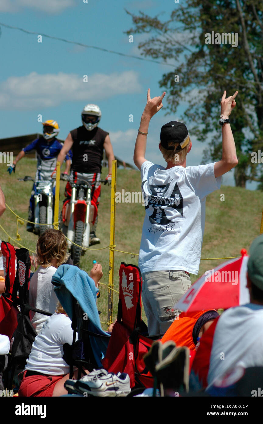 Fan Stands flashing devils horns ROCK sign with hands to riders, Inwood Ontario Canada Stock Photo