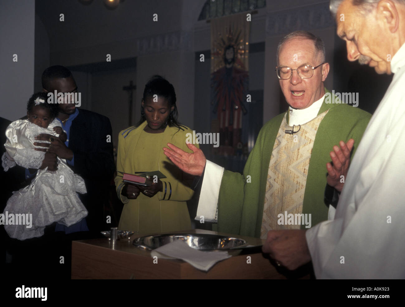 Catholic baptism ceremony with officiating priests London Stock Photo