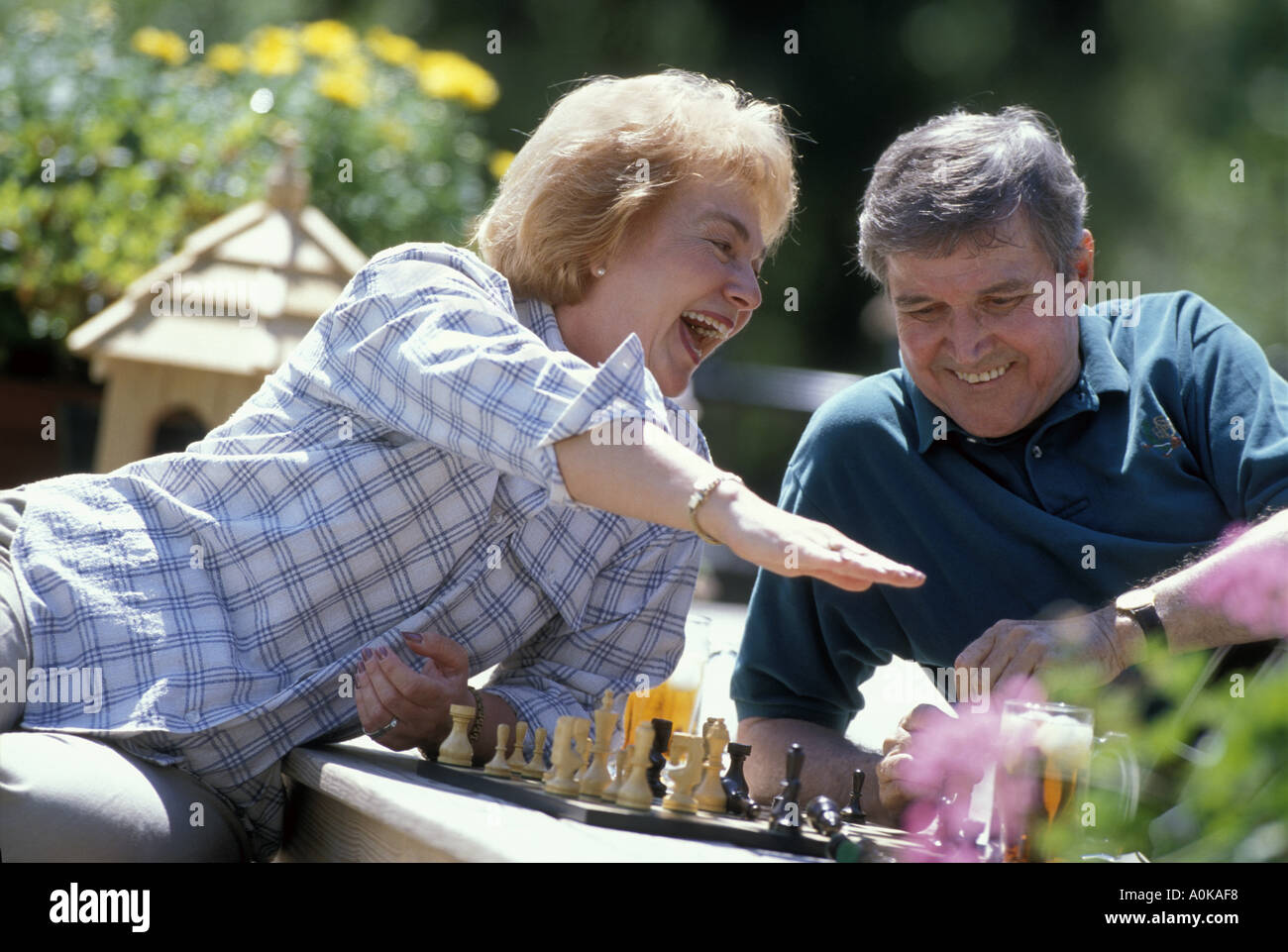 Caucasian senior couple playing chess game on deck Stock Photo