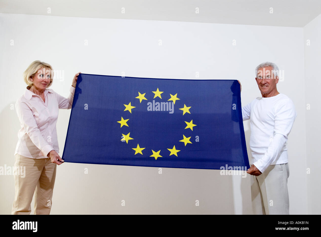 two mature people holding flag of European Union Stock Photo