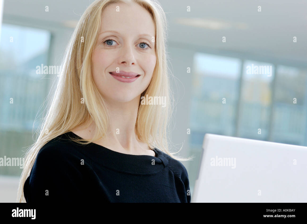 confidently smiling woman sitting behind her computer Stock Photo - Alamy