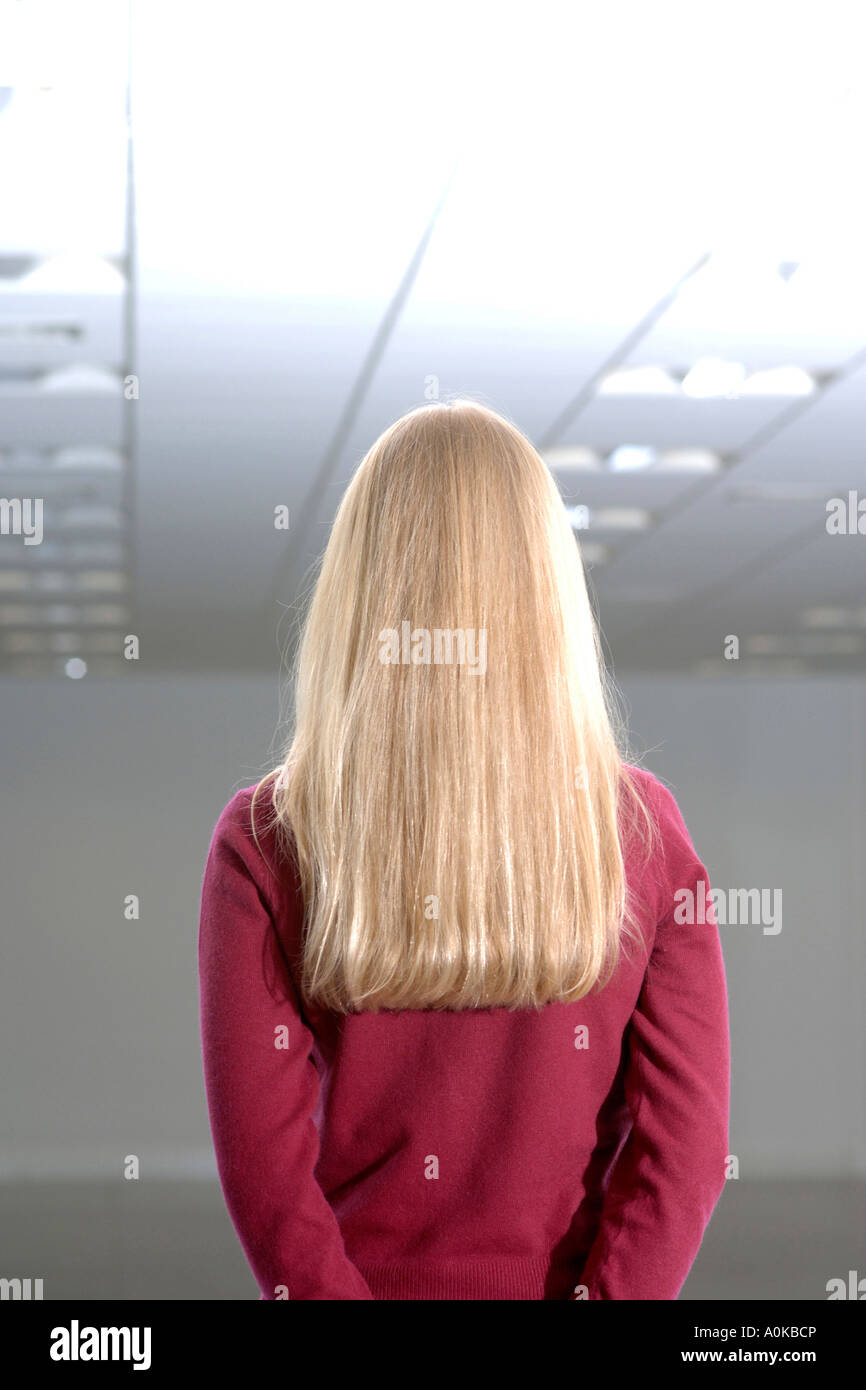 rear view of blond woman standing in empty office space Stock Photo - Alamy
