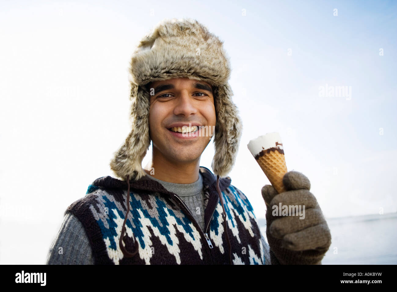 smiling man with fur hat having an ice cream Stock Photo