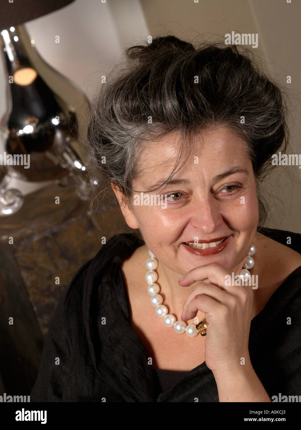 portrait of Mrs Maroeska Metz a famous Dutch designer artist The lamp in the background and the necklace are her own designs Stock Photo