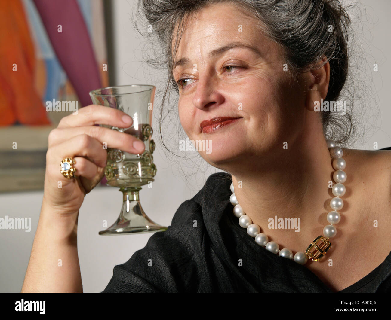 portrait of Mrs Maroeska Metz a famous Dutch designer artist necklace ring and wine glass are her own designs Stock Photo