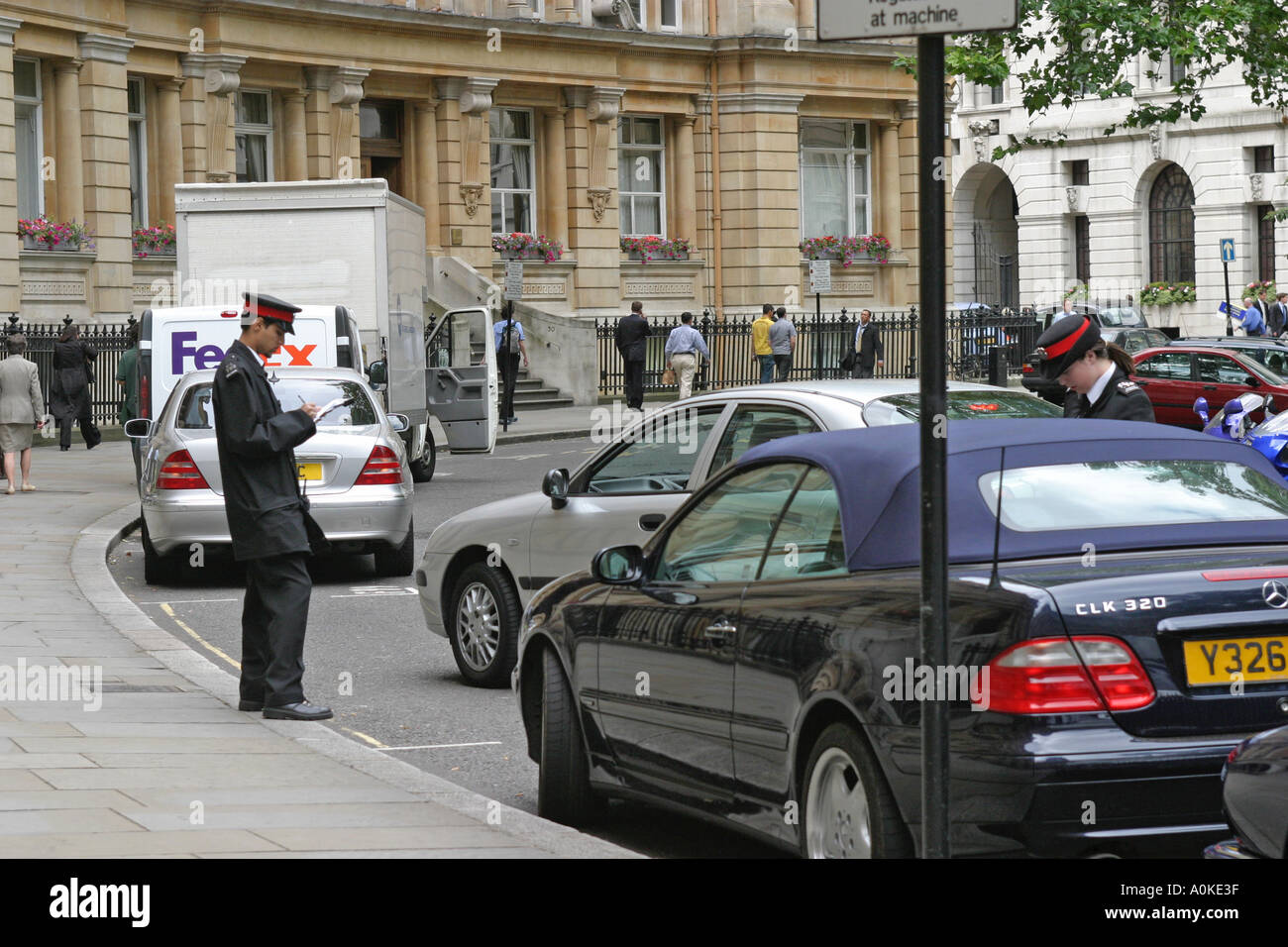 Traffic wardens writing out parking tickets in City of London Stock Photo