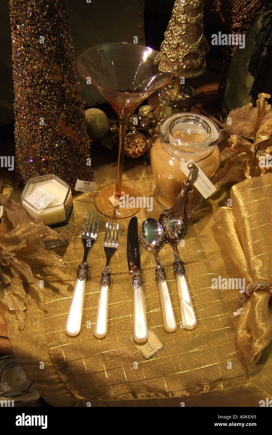 A set of table ware is displayed on a table with a wine glass and candles Stock Photo