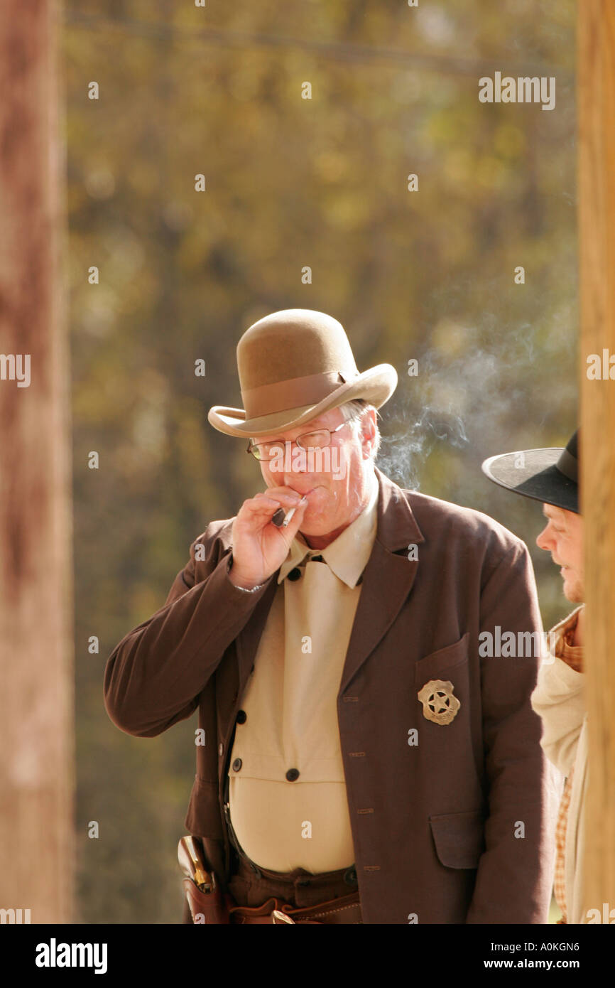 Cowboy smoking on boardwalk Stock Photo
