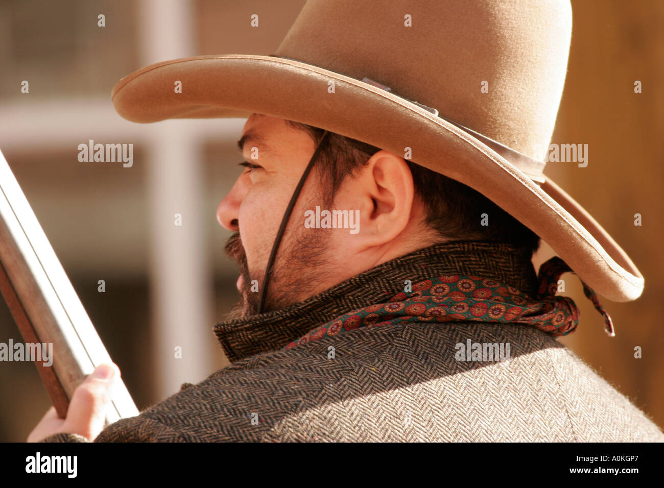 A cowboy with a gun is walking through town Stock Photo