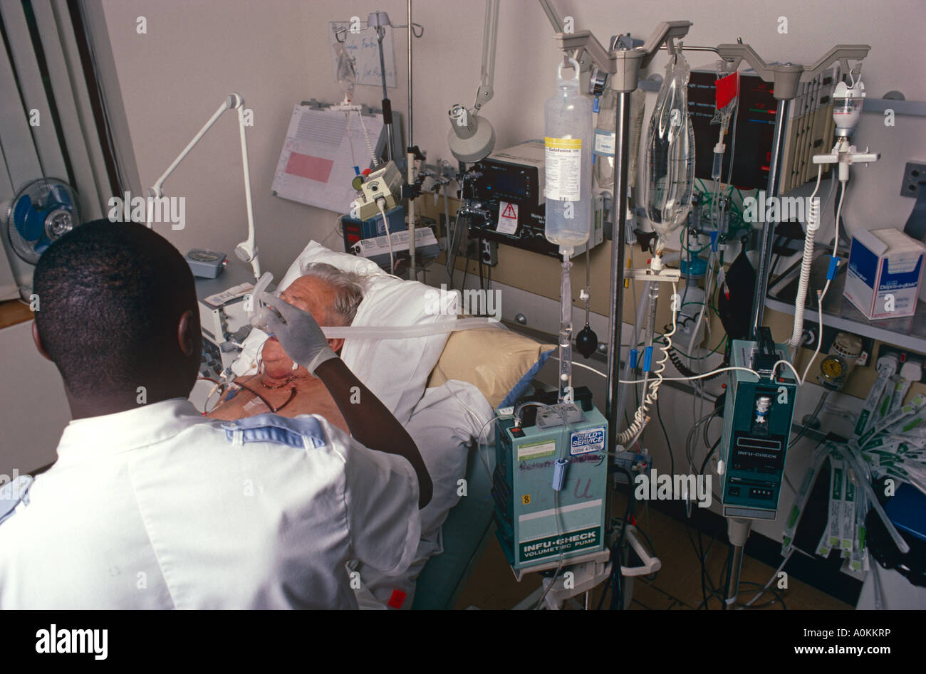 A male staff nurse giving oxygen to a patient in the intensive care unit of a London Hospital, UK Stock Photo