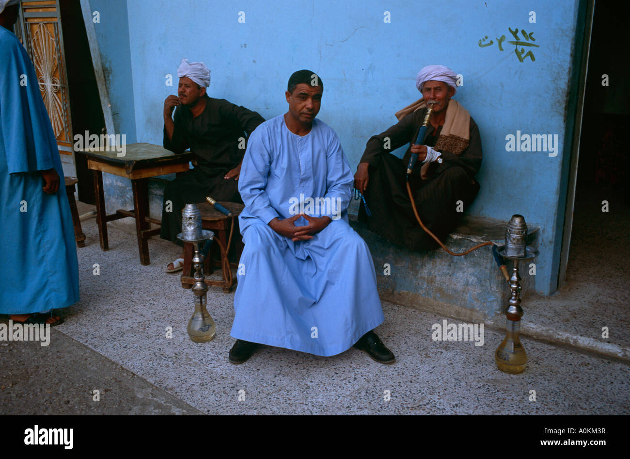 An Egyptian man smokes a hookah at a cafe in the village of Gesirat Elbaraat, on the west bank of the Nile at Luxor, Egypt Stock Photo