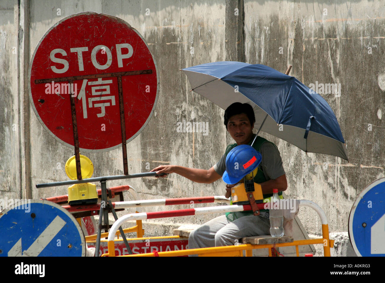 Construction worker stops traffic, Hong Kong Stock Photo