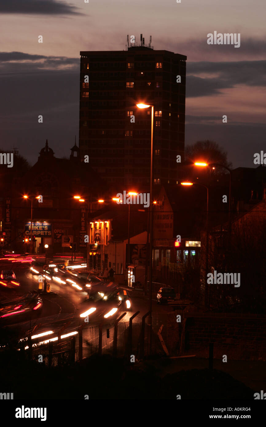 Busy road at dusk with flats/apartments in background in Leeds, Yorkshire Stock Photo