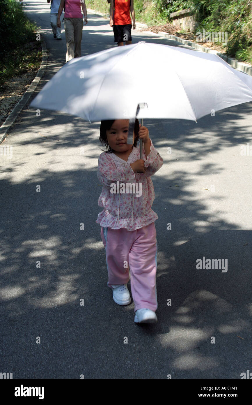 Little asian girl and her sun umbrella, Tai Tam  resevoir hike Stock Photo