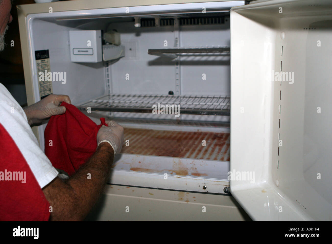 Man cleaning a freezer after hurricane Katrina Stock Photo