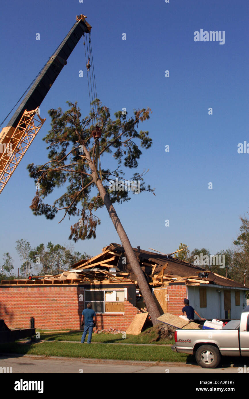 Men using a crane to remove a tree from a house in Slidell Louisiana during the aftermatch of Hurricane Katrina Stock Photo