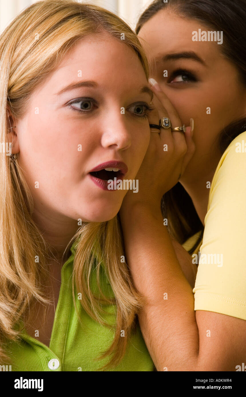 Caucasian Teen Girl 18 to 19 Whispers Shocking Secret in the Ear of Her Friend USA Stock Photo
