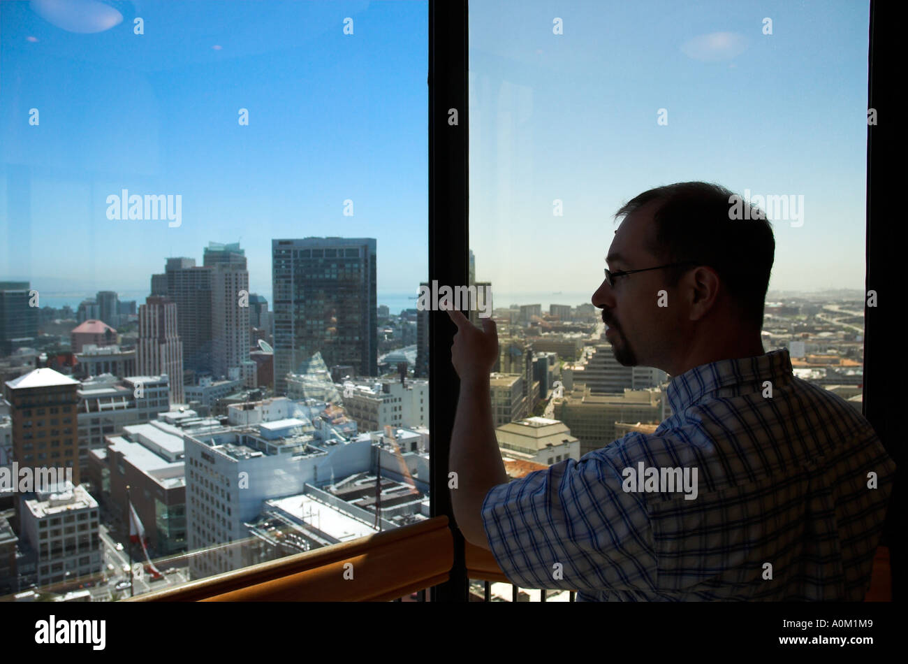 Tourist looking out of glass elevator in St Francis hotel, San