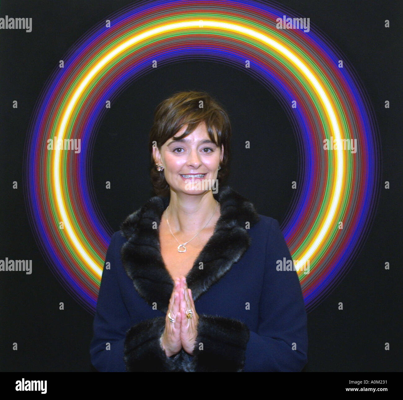 Cherie Blair, with her hands together in a mock praying gesture, standing in front of a halo like work of art Stock Photo