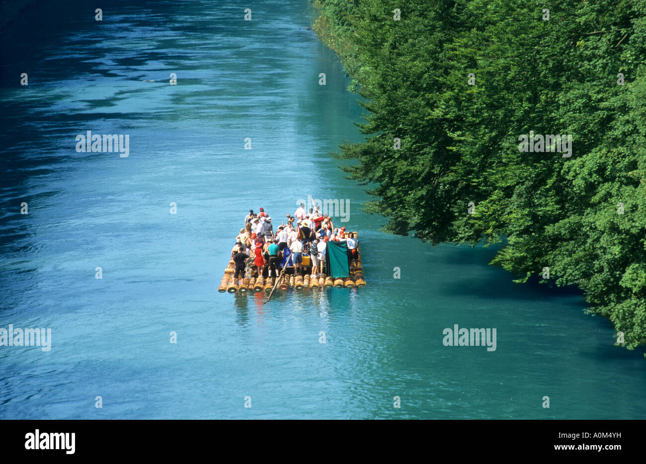 people on a raft made of tree logs on river Isar near Munich Germany ...