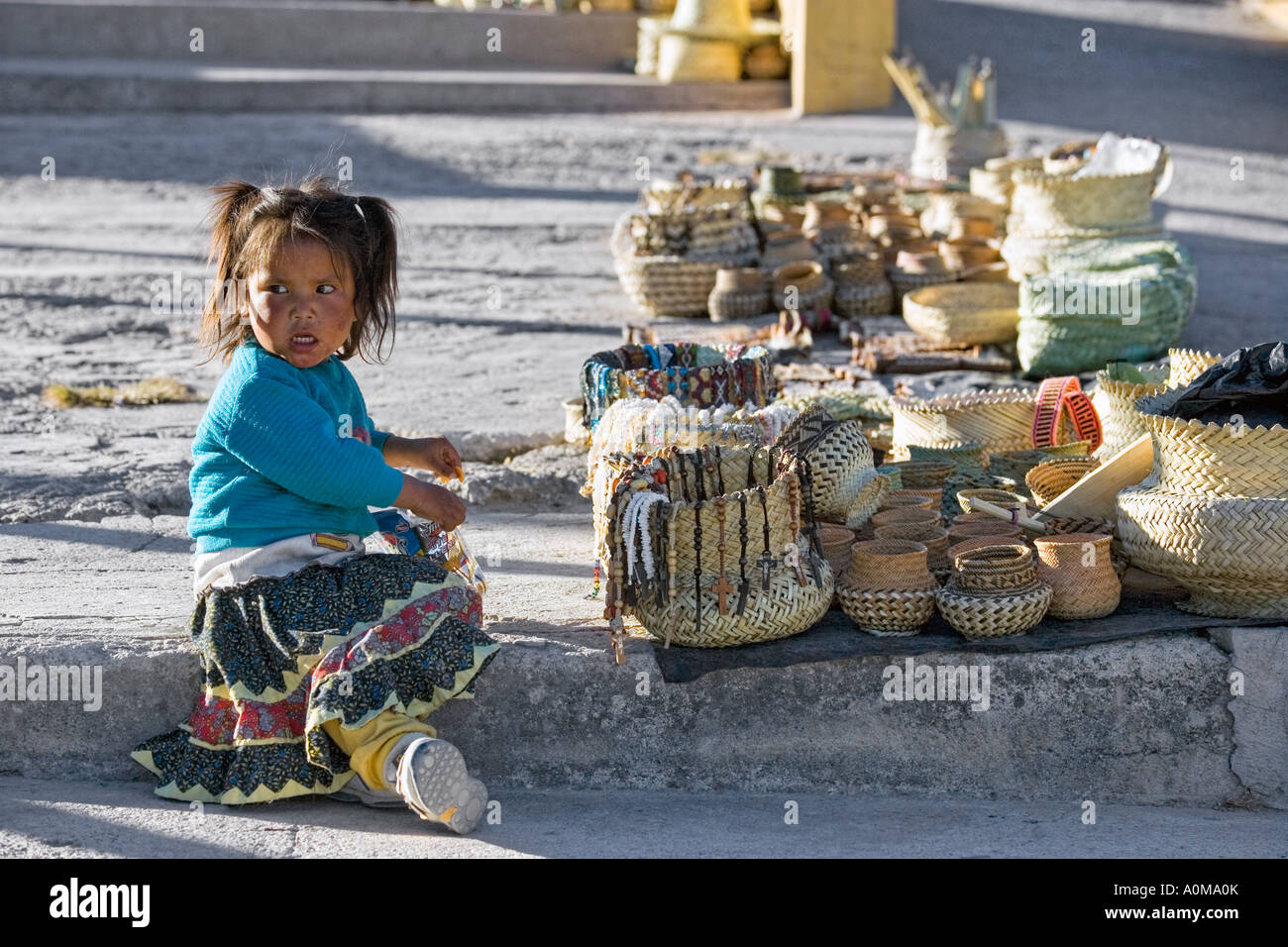 Tarahumara girl near sitting near locally made artifacts for sale to tourists and visitors in Divisadero in Copper Canyon Stock Photo