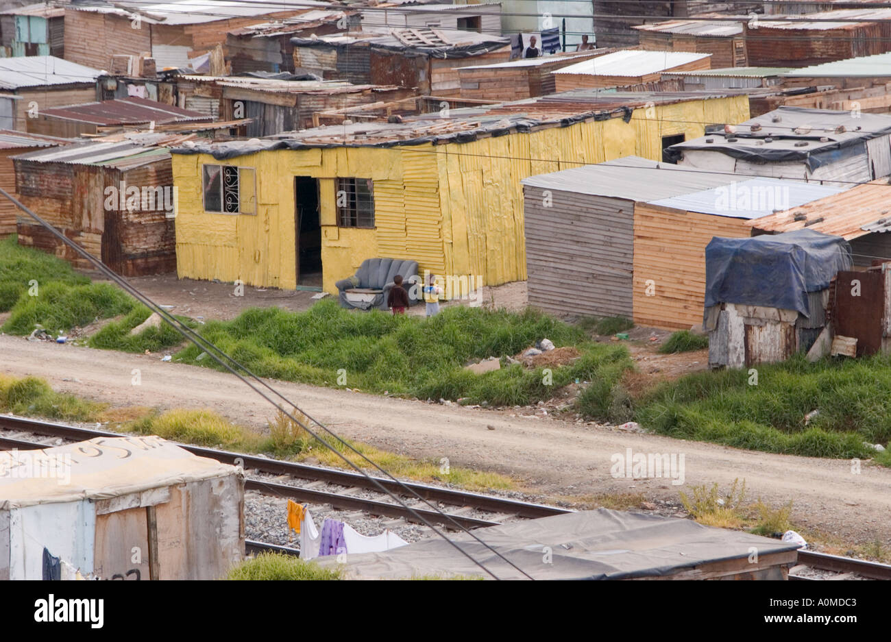 A view of some shacks and a road and railroad tracks in the township of Khayelitshu in Cape Town South Africa Stock Photo