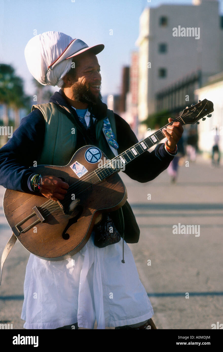 Eccentric busker playing guitar on roller skates at Venice Beach, Santa