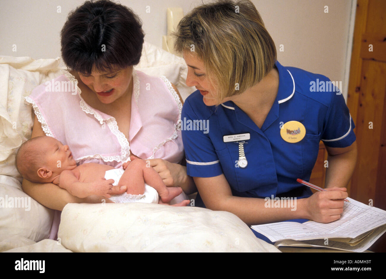 young community midwife on home visit with new mother taking post natal  notes Stock Photo - Alamy