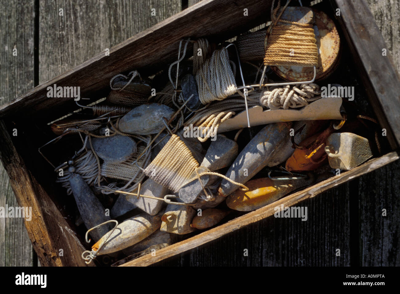 https://c8.alamy.com/comp/A0MPTA/close-up-box-of-fishing-accessories-hand-line-sinkers-dock-rope-wood-A0MPTA.jpg