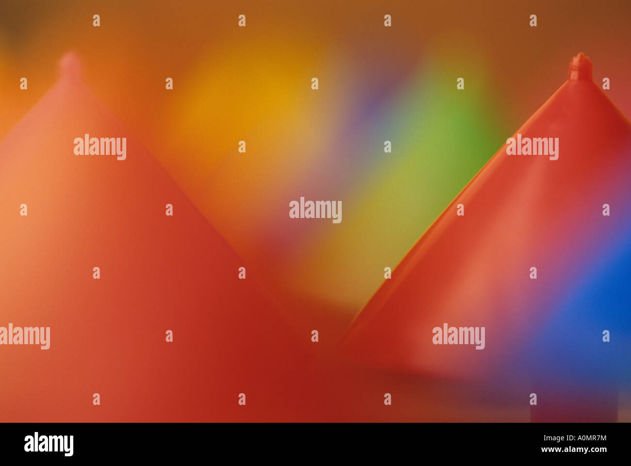 Multi colored spinning tops upside down with red as the dominant color