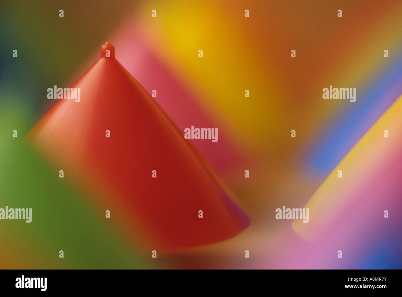 Multi colored spinning tops upside down with red as the dominant color