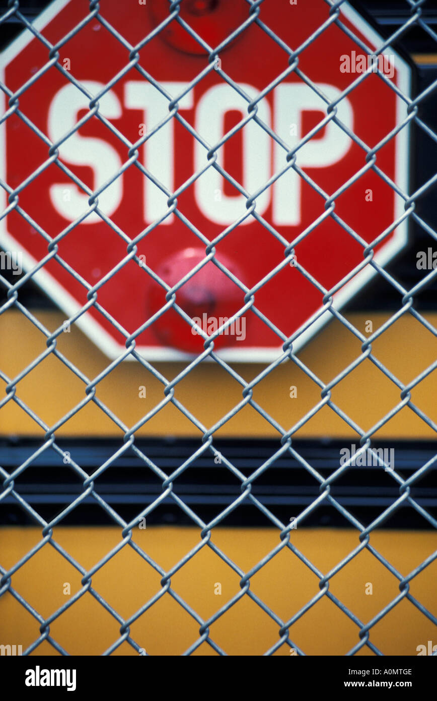 yellow school red bus stop sign chain link fence Stock Photo