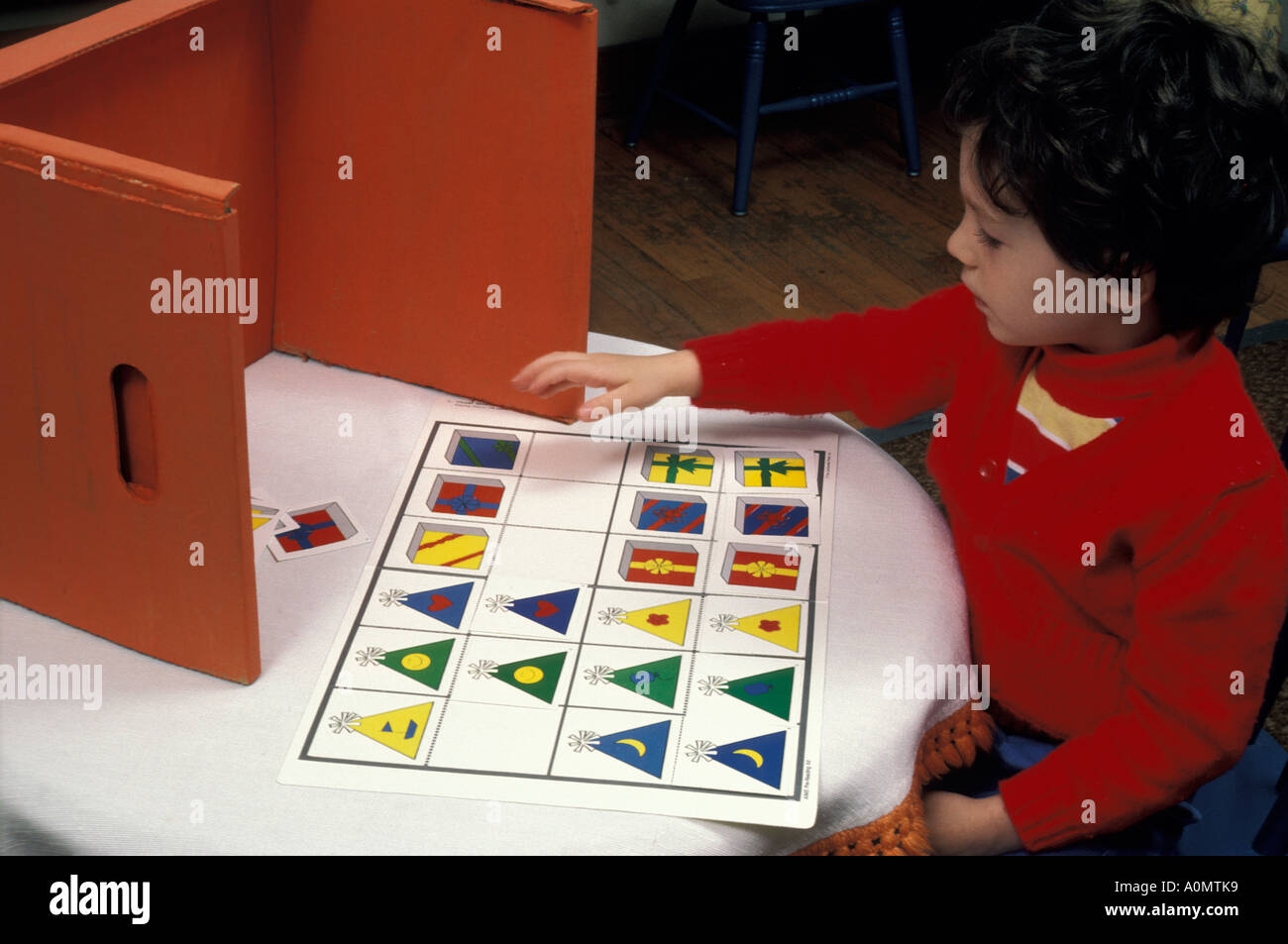 student places matches geometric shapes students kids child children concentrating skill group cutting shapes knowledge wisdom Stock Photo