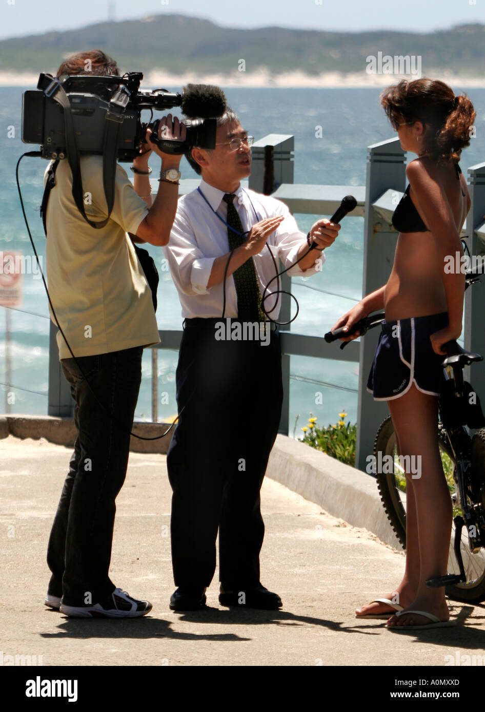 A Japanese Television crew interview a teenage girl at Cronulla Beach in Australia Stock Photo