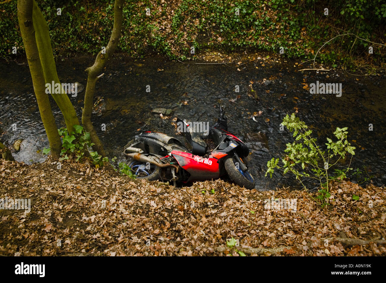 A broken motor scooter dumped by the River Ching, Highams Park, London, UK Stock Photo Alamy