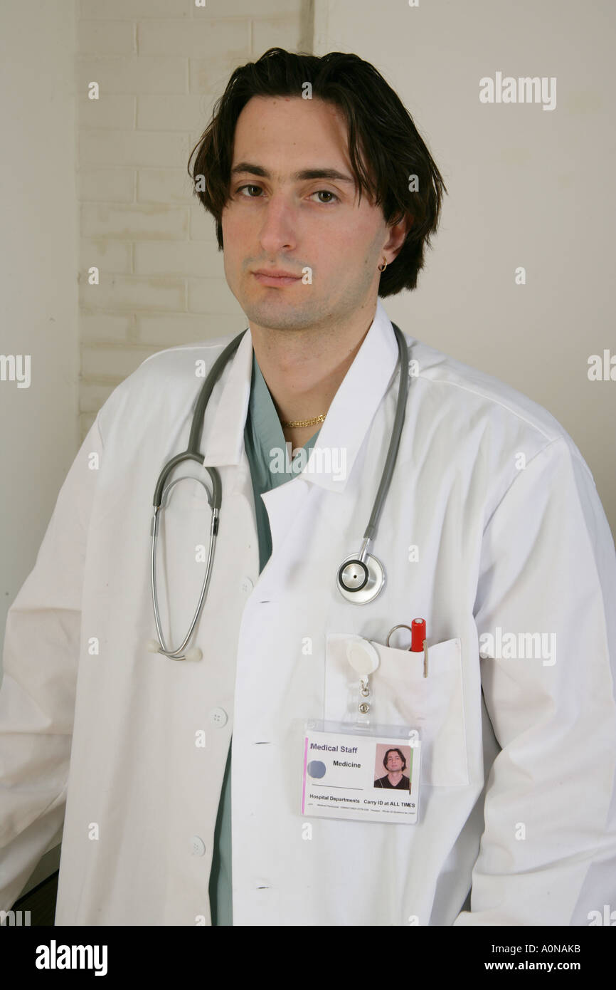Male physician with white lab coat, ID and stethoscope in clinic or