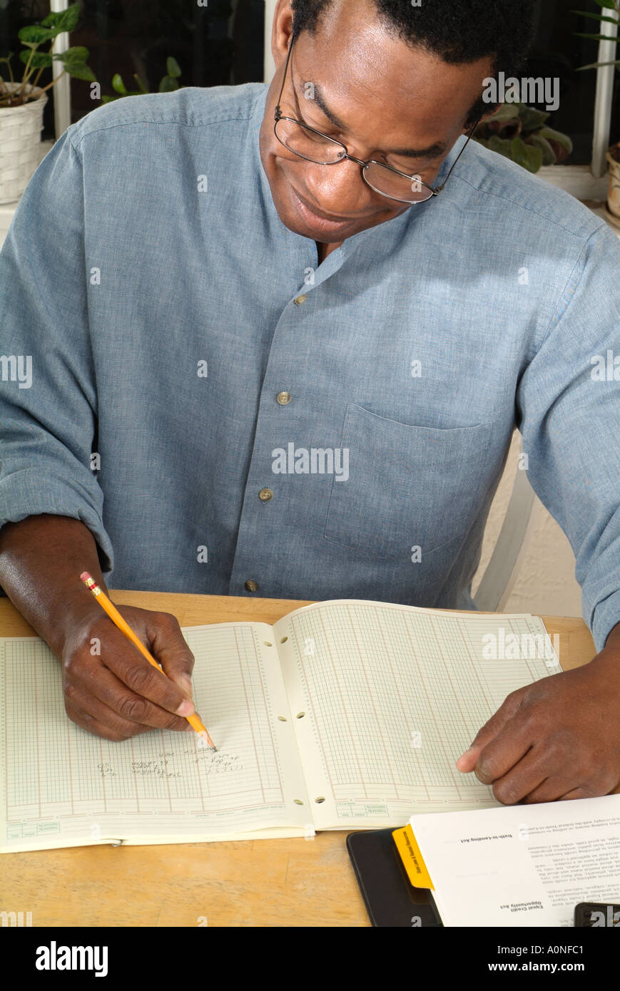 Man in home office doing his taxes, accounting or bookkeeping Stock Photo