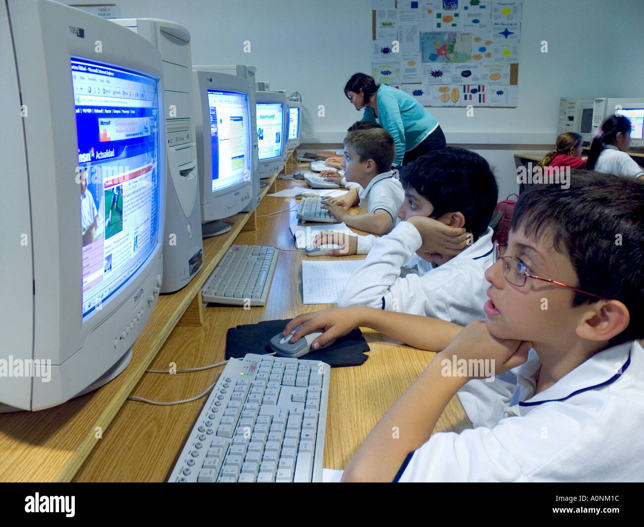 Junior multicultural  school children with teacher study in their modern spacious computer classroom Stock Photo