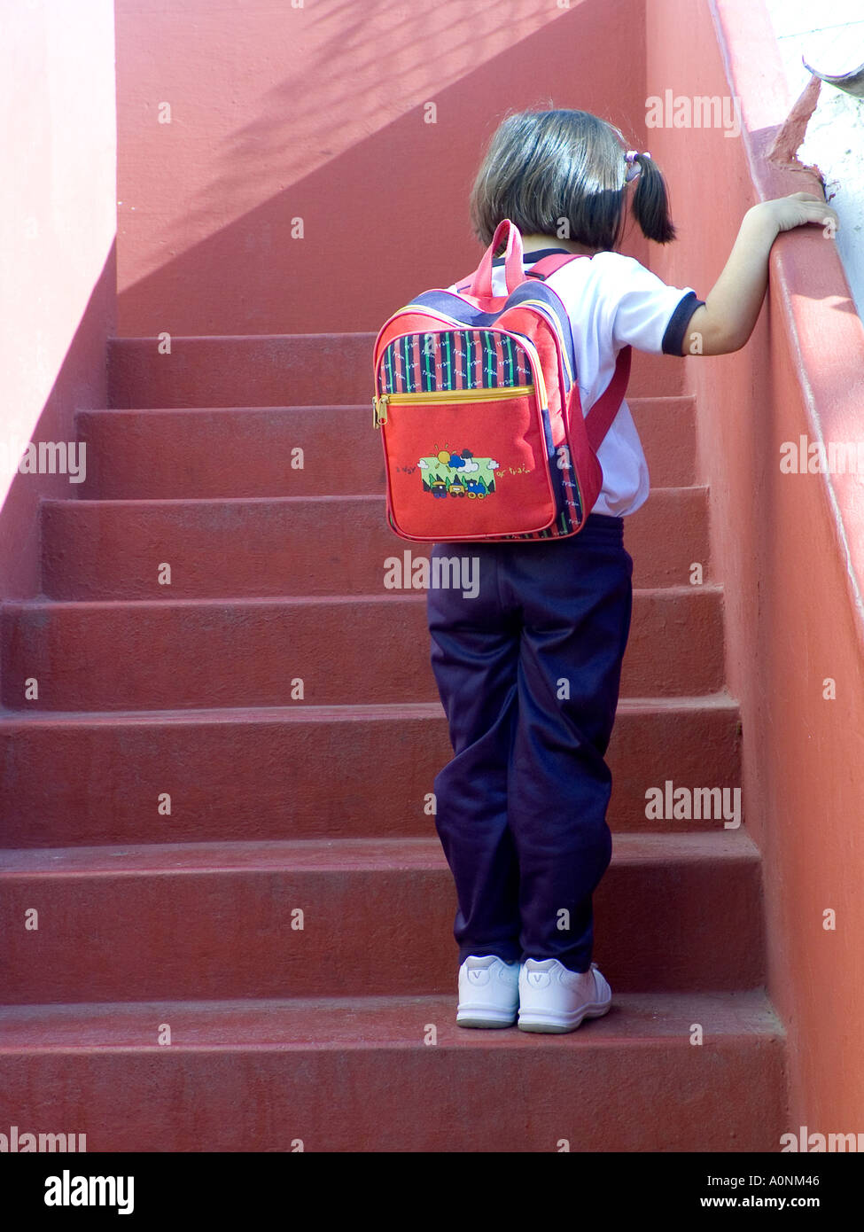 First day at school Infant school girl pauses in thought on steps leading to classroom Stock Photo